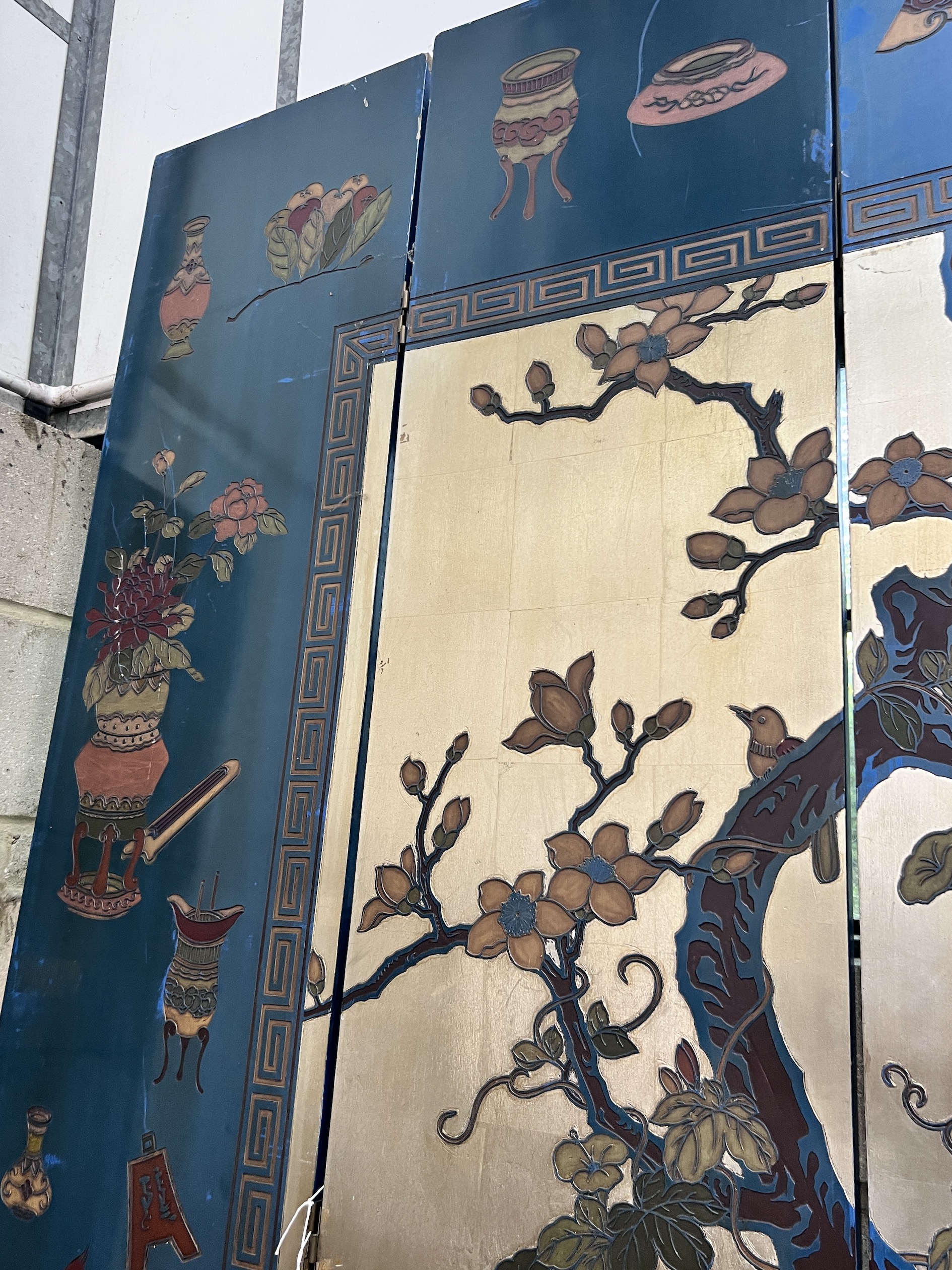 A Chinese lacquered eight fold screen decorated with exotic birds among flowering trees, each panel width 40cm, height 244cm (no fixing clips)